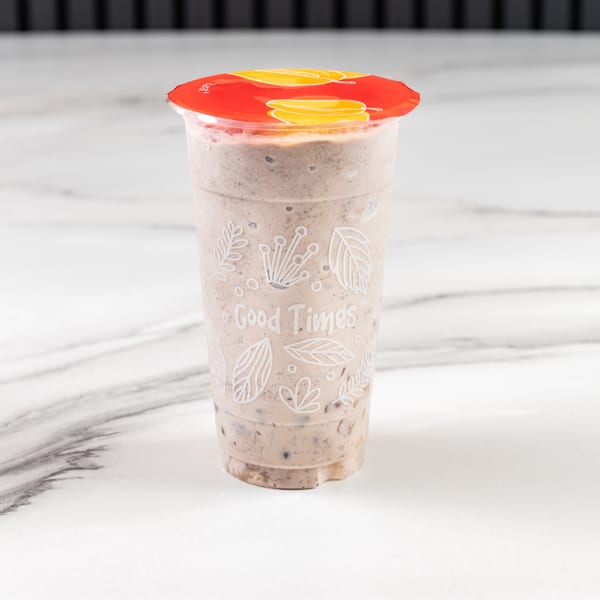 A Vietnamese Phở 95 cookies and cream smoothie with a red lid on a marble surface.