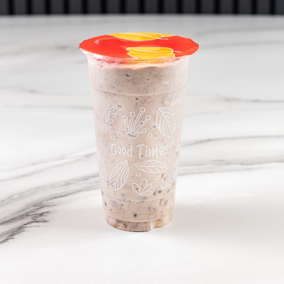 A Vietnamese Phở 95 cookies and cream smoothie with a red lid on a marble surface.